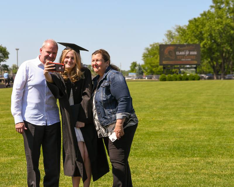 Sycamore graduate Grace Schumaker takes a selfie with her parents, Michael Schumaker and Jennifer Jeffries, on the football field of Sycamore High School on Sunday, May 24, 2026, after the Class of 2026 Commencement.