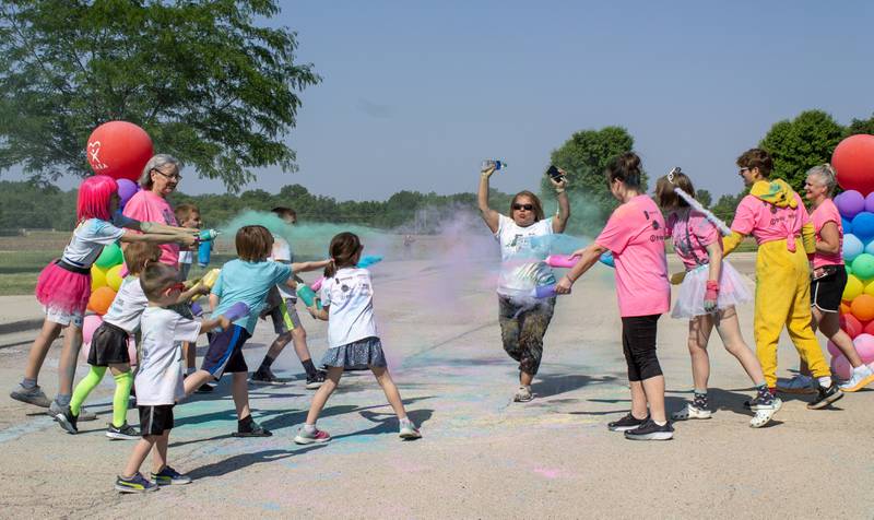 Volunteers get ready to cover a participant in color as they approach the finish line during CASA DeKalb County's annual 5K Color Run on Saturday, June 3, 2023. All proceeds from the event help to support training for advocates.