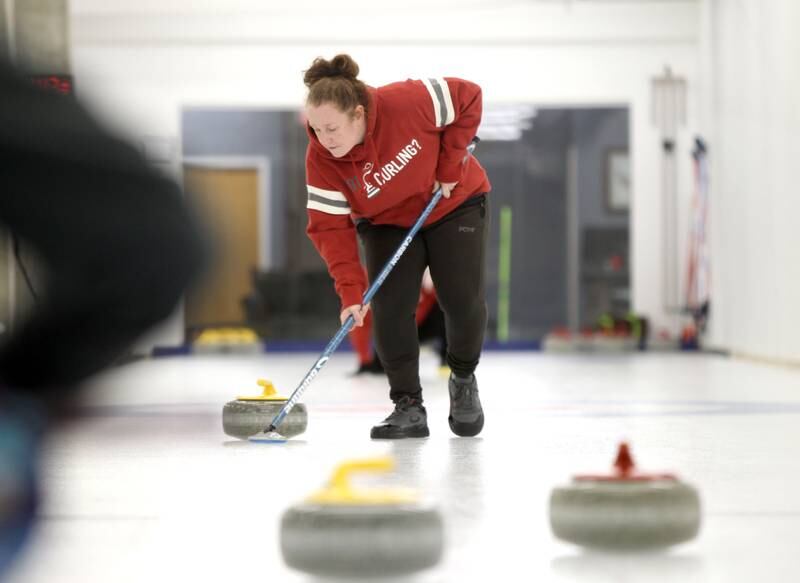 Siobhan Cogswell of Itasca sweeps ahead of the stone during a drop-in game of Curling at the Windy City Curling Club in Villa Park.