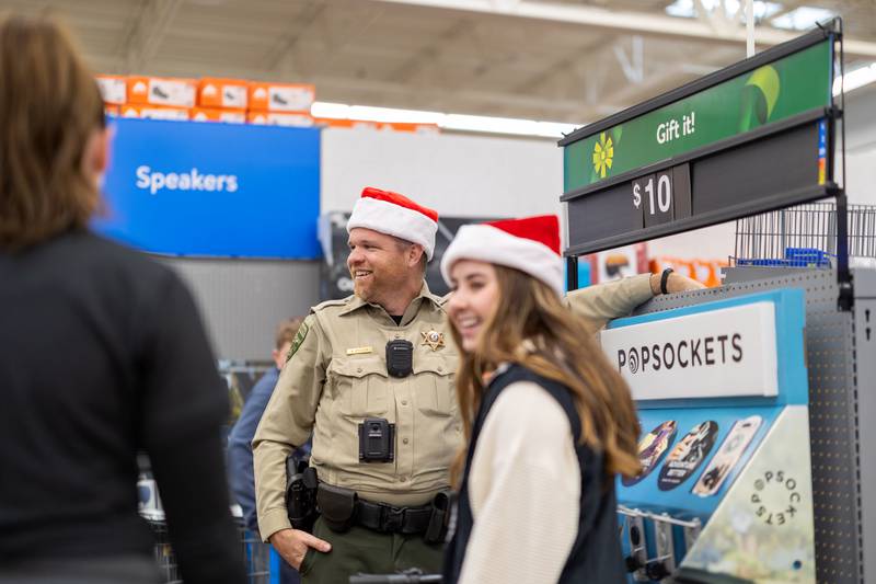 Lee County officer Kyle Kellen smiles as he chats with other officers during the Shop with a Cop event in Dixon on Saturday, December 14, 2024. Several different departments participated in this year's event, including Dixon Police and Lee County Sheriff.