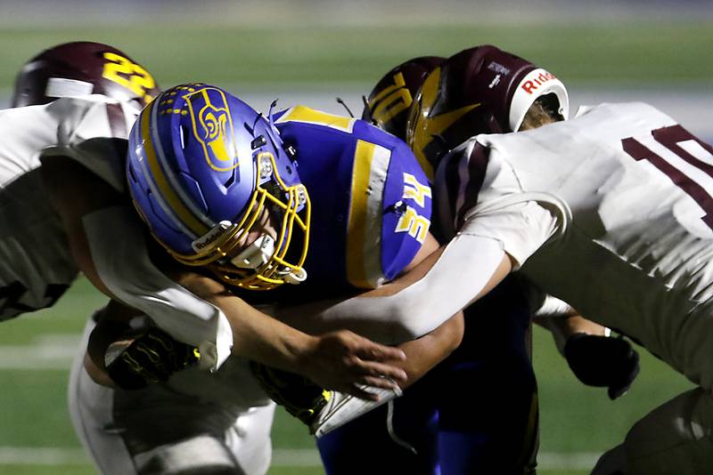 Richmond-Burton's Gavin Busa (left) and Luke Robinson (right) tackle Johnsburg's Duke Mays during a Kishwaukee River Conference football game on Friday, Sept. 12, 2025, at Johnsburg High School.