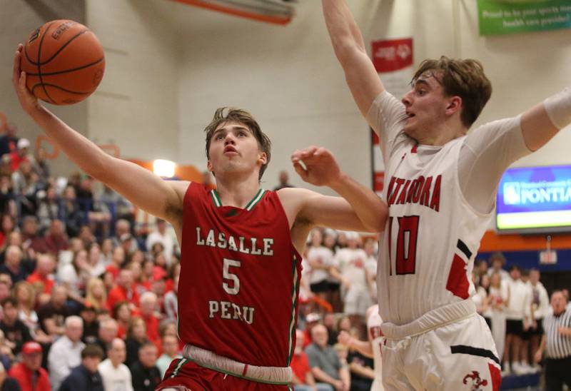 L-P's Seth Adams eyes the hoop as Metamora's Tyler Mason defends during the Class 3A Sectional on Tuesday, Feb. 27, 2024 at Pontiac High School.