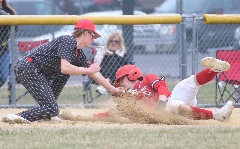 Hall third baseman Hunter Edgecomb tags out Streator's Colin Byers while sliding into third base on Tuesday, March 18, 2025 in Foley Field at Kirby Park in Spring Valley.