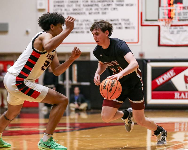 Plainfield North's Quintin Wiencek (34) is defended on a drive by Bolingbrook's Joshua Pettigrew (22) during their basketball game between Plainfield North at Bolingbrook, Friday Dec 13, 2024 in Bolingbrook.