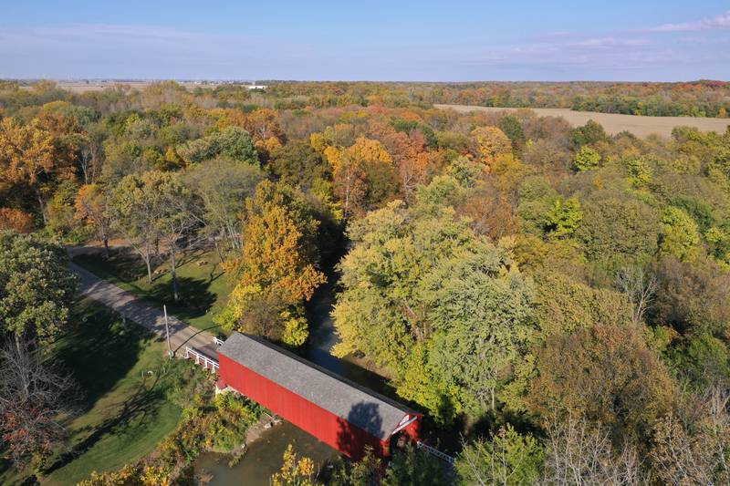 An aerial view of fall colors at the Red Covered Bridge on Monday, Oct. 23, 2023.