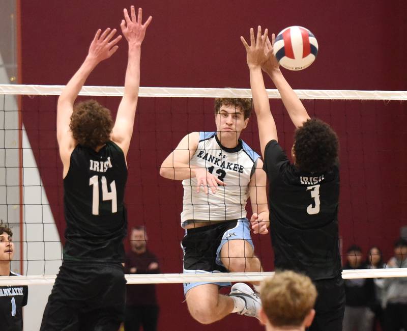 Kankakee's Eli Cunningham, center, watches his kill go past Bishop McNamara's Oliver Heinrich, left, and Sean Price during a game at Kankakee Tuesday, March 31, 2026.