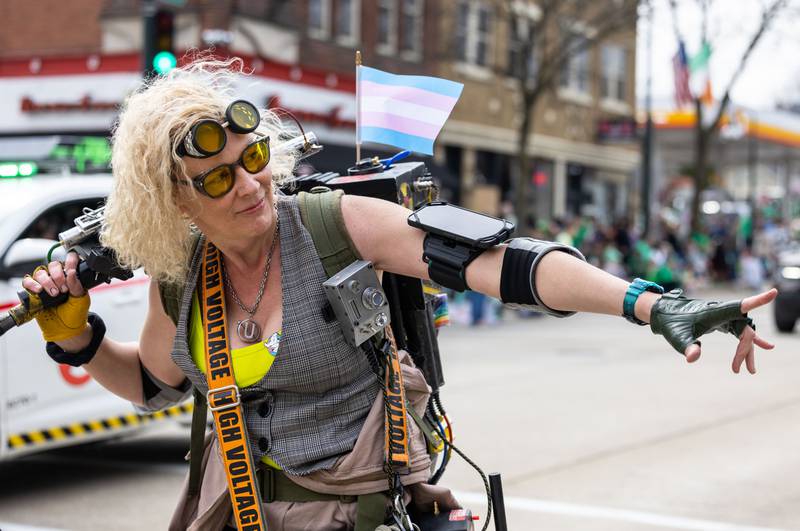 A member of the Windy City Ghostbusters waves to the crowd during the St. Charles St. Patrick’s Parade on Main Street in St. Charles on Saturday, March 15, 2025.