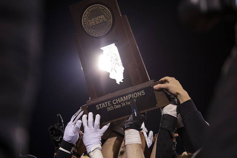 Byron hoists their first place trophy Friday, Nov. 28, 2025, in the Class 3A football finals at Hancock Stadium at ISU.