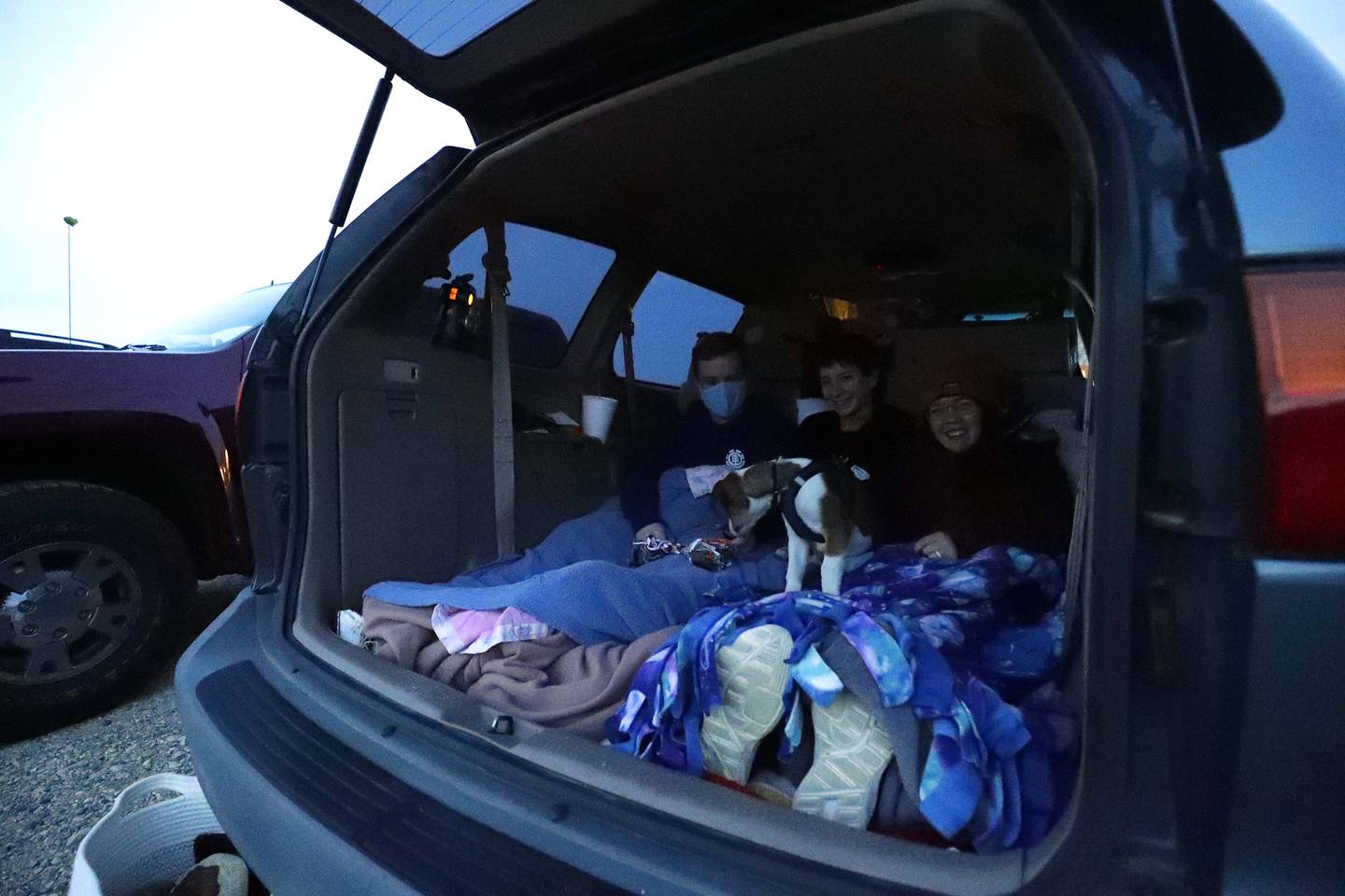 Andrew Pierce, of McHenry, from left, Bonnie Spriester, of Mundelein, and Melanie Manahan of Crystal Lake snuggle with their dog Leo who was at his first movie at McHenry Outdoor Theater when it reopened Friday April 30, 2021, in McHenry.