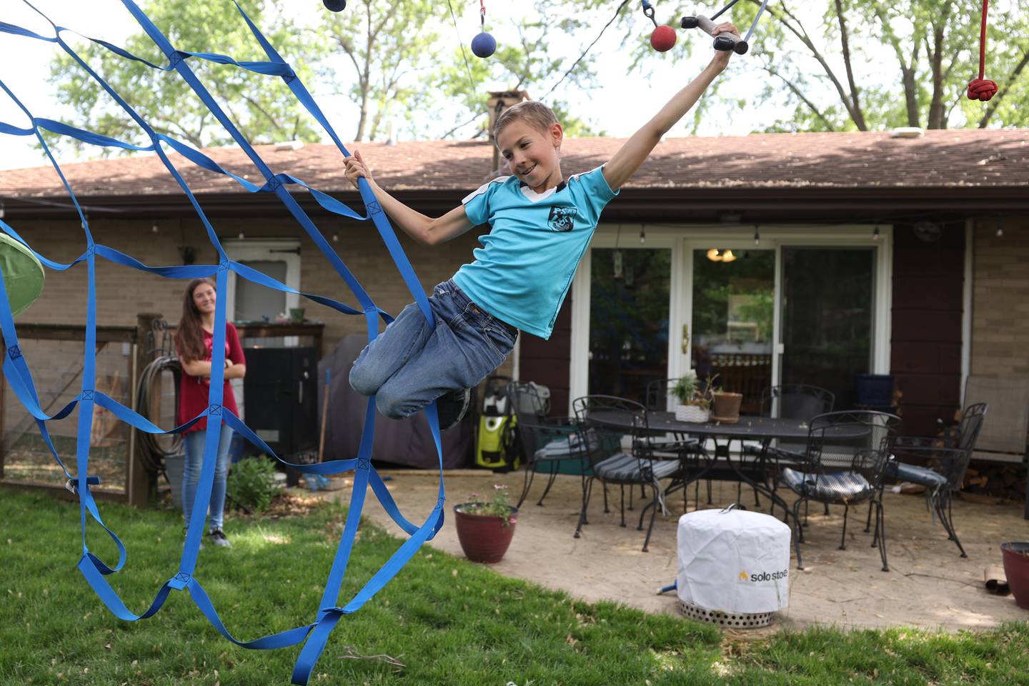 Emerson Ruland, 10, shows off his obstacle course skills to his sister Ella, 13, in their backyard. Tuesday, May 24 2022, in Plainfield.