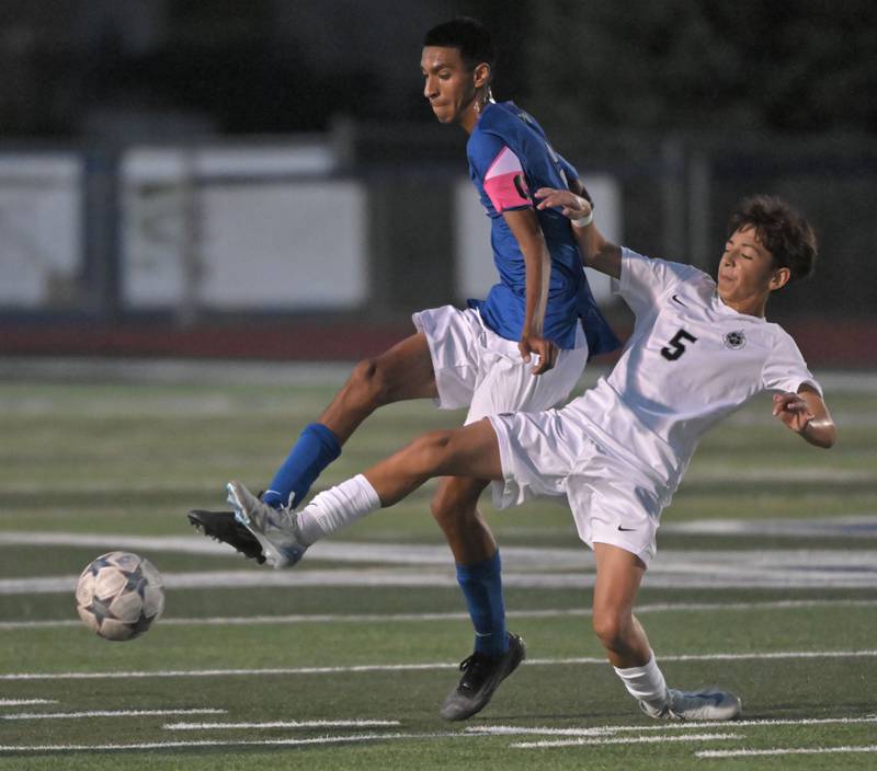 West Chicago’s Julian Lopez bends an ankle as he plays against St. Charles North’s Diego Torres in a boys soccer game in St. Charles on Wednesday, Sept. 4, 2024.