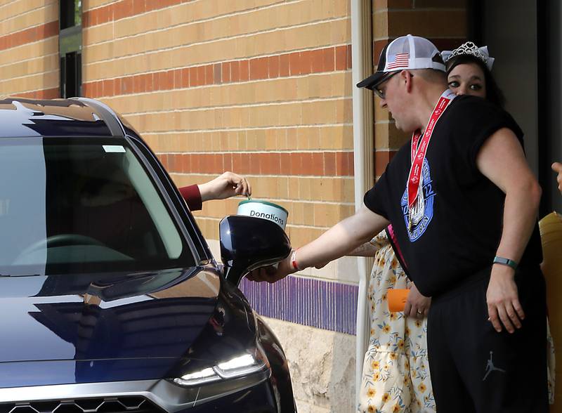 Special Olympian James Williams collects donations during the Cop on a Rooftop fundraiser to raise awareness for Special Olympics Illinois and the Law Enforcement Torch Run to benefit Special Olympics on Friday, May 19. 2023. Huntley Police Department officers, in support of the Law Enforcement Torch Run for Special Olympics Illinois, took to the roofs and ground around both Huntley Dunkin’ Donuts locations before finishing the day with the seventh annual donut-eating contest that was won by Matthew Ganek of the Huntley Police Department.