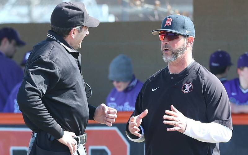 DeKalb head coach Josh Latimer talks to an umpire between innings during their game against Dixon Tuesday, March 28, 2023, at DeKalb High School.