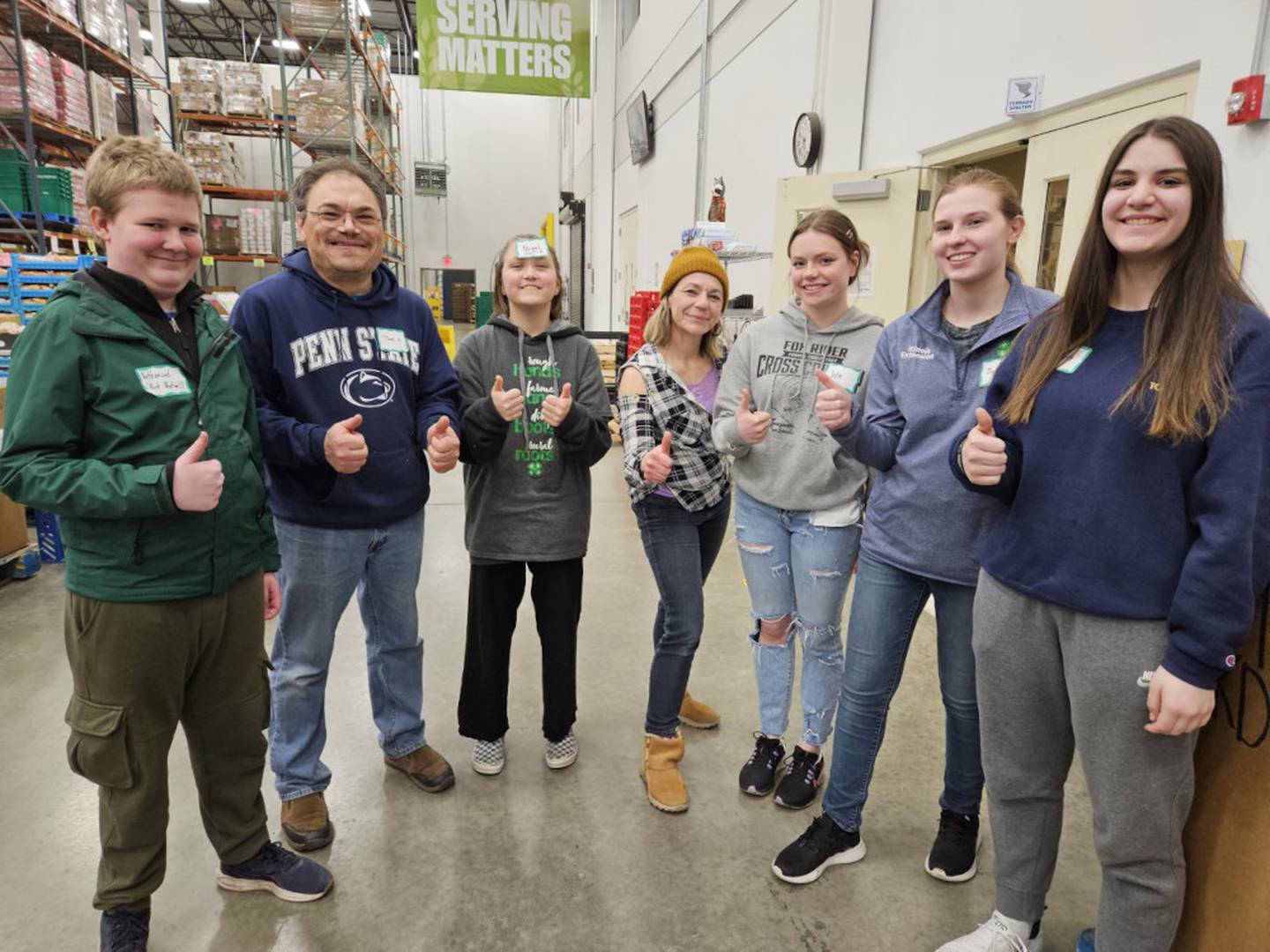 4-H Teen Federation members and adult volunteers stop for a photo during their community service at Northern Illinois Food Bank.