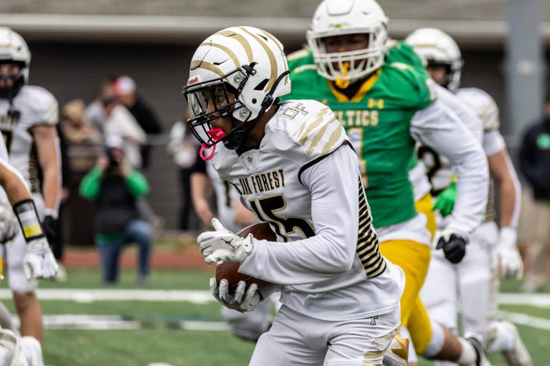 Oak Forest's Neiko Leflore picks-up yardage during a 5A varsity football semifinal game against Providence at Providence Catholic High School on Nov. 22, 2025.