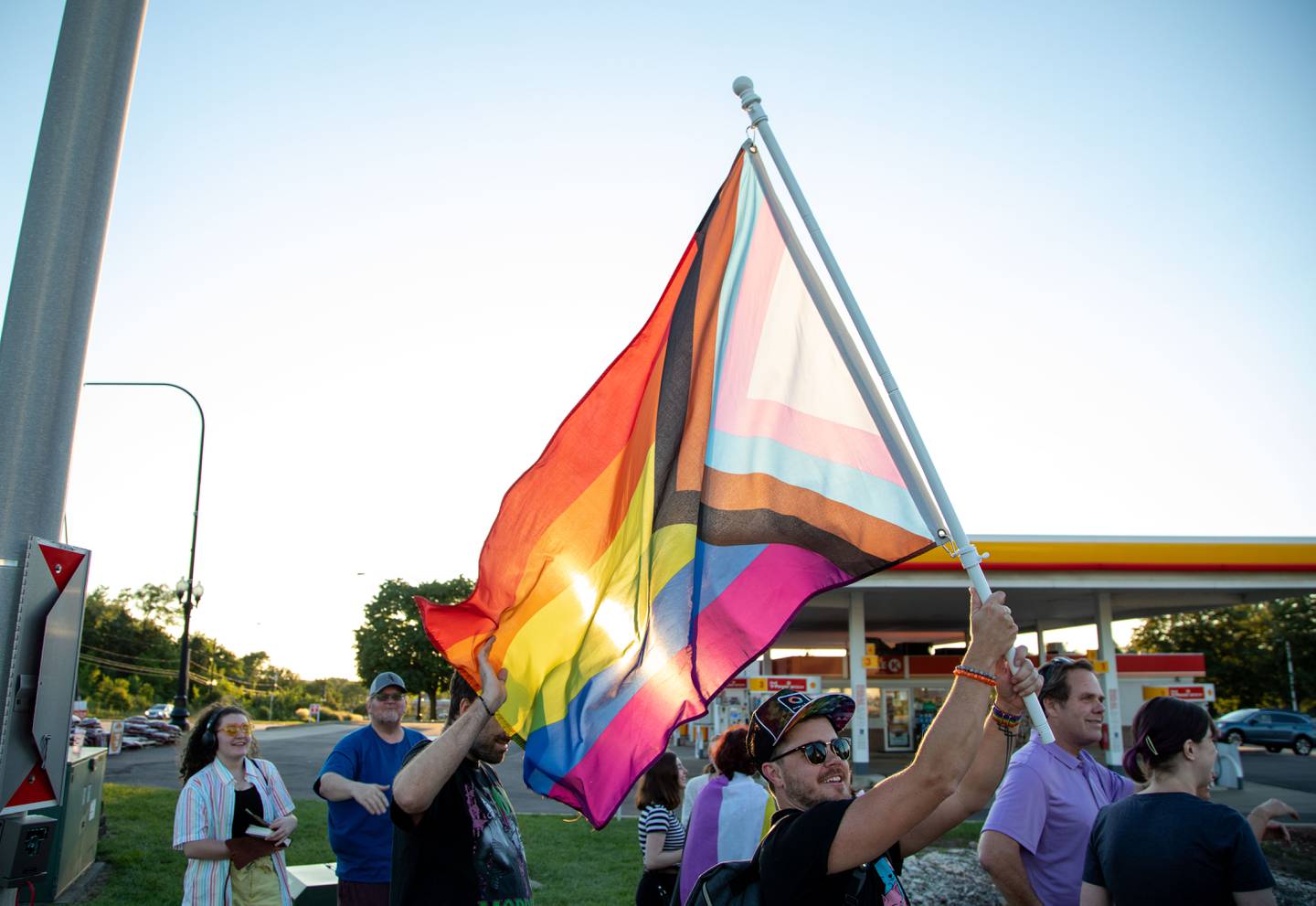 Caleb Anderson waves a pride flag during the Pride Fire Hydrant Rally at the northwest corner of Kirk Road and State Street/Rte. 38 in Geneva on Tuesday, Aug. 9, 2022.