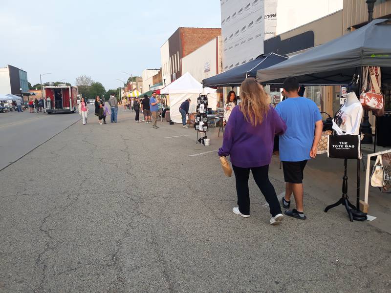Visitors at GROW Spring Valley's first Friday Night Market peruse the 40 artisan vendors Friday, May 19, 2023, along St. Paul Street.
