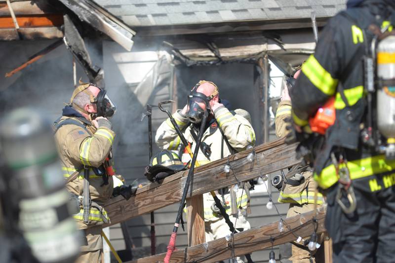 Firefighters put on their oxygen apparatus before entering a home at 2010 S. Second St. in Daysville on Wednesday, March 12, 2025.