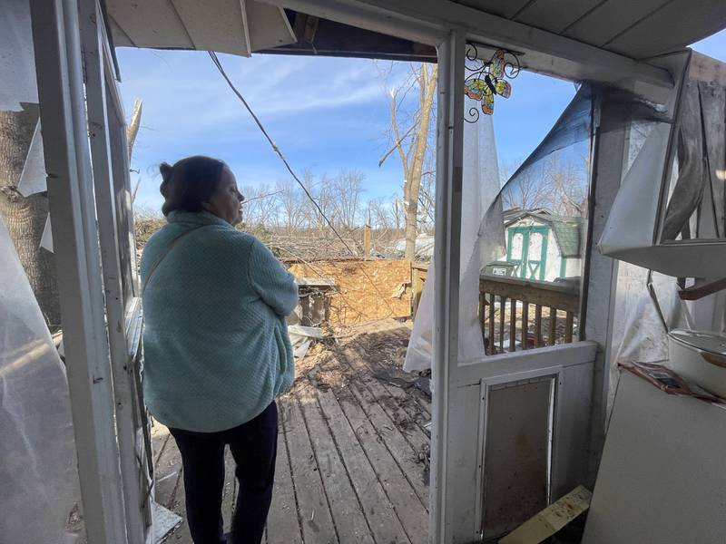 Aroma Park resident Patricia Kime looks out over the destruction in the backyard of her home on Strasma North Drive as she recounts the the March 10 EF-3 tornado that destroyed many homes in the area.
