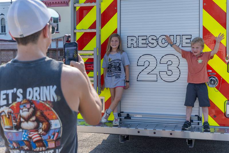 (left to right) Ian Thomas takes photo of his children Kairi and Dexter on Saturday, August 9, 2025 at the annual Wenona Days on Chestnut Street in Wenona.