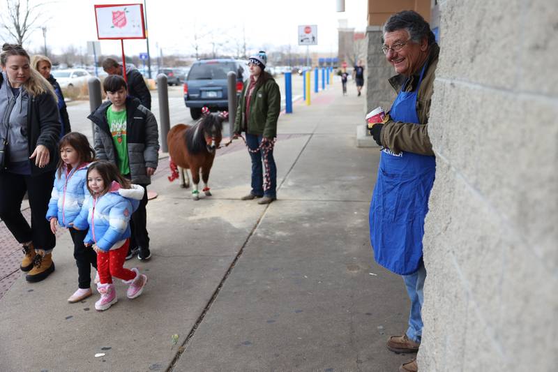 Will County Trail Riders President Bruce Bochenek, right, smiles as shoppers interact with the horses. The Will County Trail Riders brought horses as they volunteered for the Salvation Army on Saturday, Dec. 2nd, 2023 at Walmart in New Lenox.