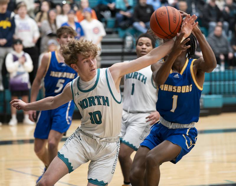 Woodstock North's Trevor Mark gets a hand in to defend Johnsburg's Jarrel Albea during their game on Wednesday, January 31, 2024 at Woodstock North High School. Ryan Rayburn for Shaw Local