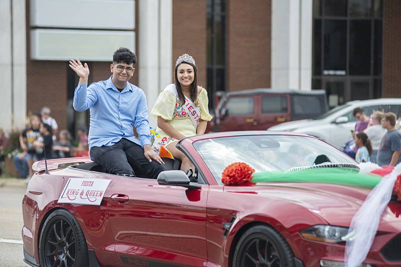 The 2022 Fiesta Parade king and queen, Julian Guerrero, 20, of Rock Falls, and Ximena Aguilar, 19, of Sterling, wave from the back of a convertible during Saturday's parade.