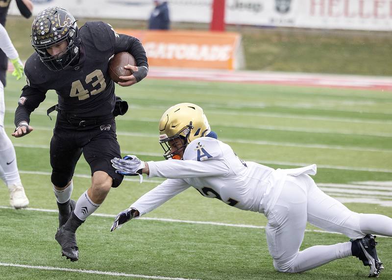 Lena-Winslow's Alec Schlichting avoids a tackle by Althoff Catholic’s Xavier Chapman Friday, Nov. 29, 2024, in the class 1A football state final.