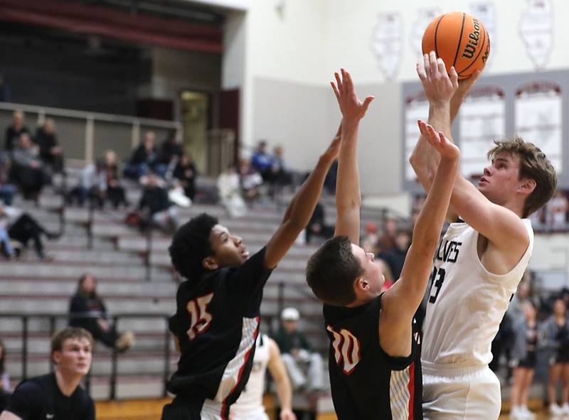 Prairie Ridge's Maddon McKim (right) shoots the ball overHuntley's Isaac Muze (left) and Brady Hassels (center)  during a Fox Valley Conference boys basketball game on Wednesday, Jan. 21, 2026, at Prairie Ridge High School in Crystal Lake.
