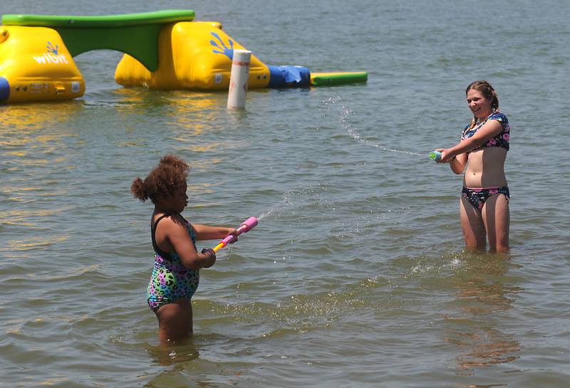 Adyson Staruck, right, and Tessa Amos, 7, play Tuesday, June 14, 2022, in the cool waters of McCullom Lake while at Petersen Park Beach, as temperatures in the McHenry County area reached the mid-90’s.
