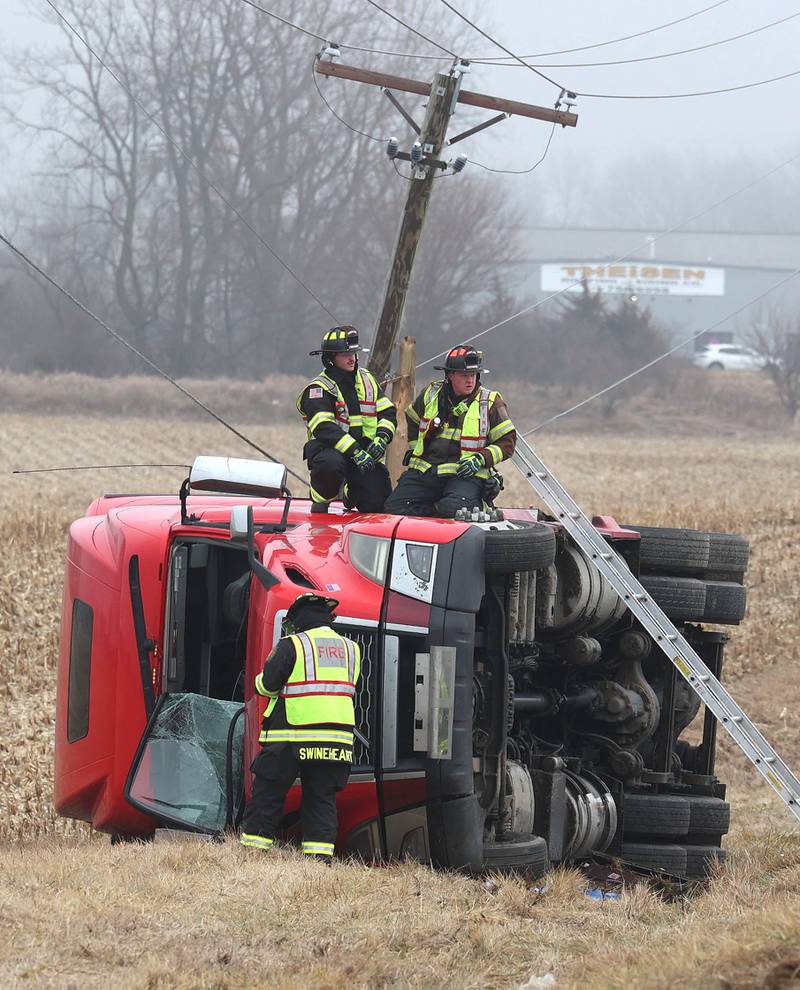 Firefighters work to secure the cab of a semitrailer that rolled into the ditch Wednesday, Jan. 7, 2026, on the north side of Lincoln Highway in Cortland.