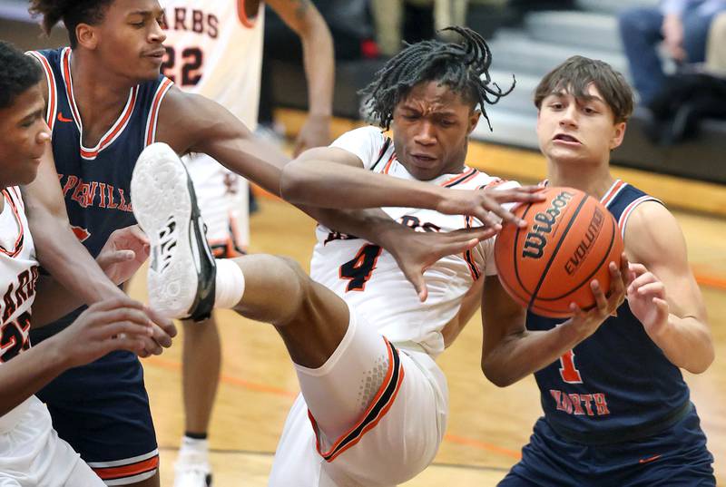 DeKalb's Johnny Henderson tries to hold on to a rebound between Naperville North's Luke Williams (left) and Cole Arl during their game Monday, Jan. 30, 2023, at DeKalb High School.
