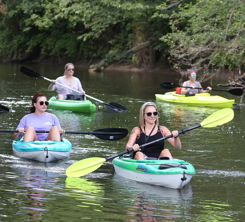 Carla Biesiadecki, (front) from Sycamore, paddles downstream with friends in the Kishwaukee River Sunday, July 31, 2022, near David Carrol Memorial Citizens Park in Genoa.