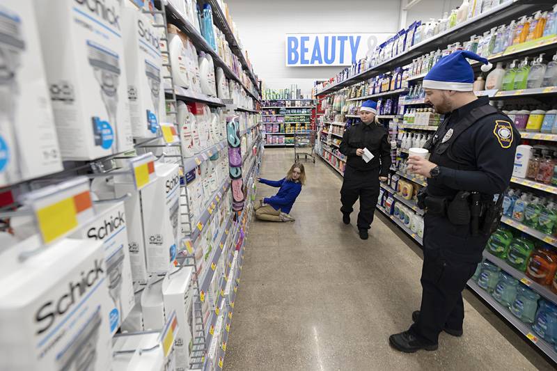 Mariah Miller looks over items Saturday, Dec. 10, 2022 at the Sterling Walmart with Police Explorer Emma Youngquist and officer Alex Kraus. Shop with a Cop was funded by community donations and a Walmart grant.
