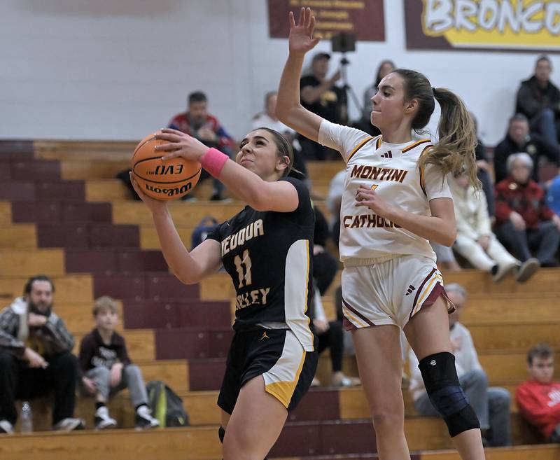 Montini’s Nikki Kerstein tries to block Neuqua Valley’s Quinn Sigal in a girls basketball game at Montini Catholic High School in Lombard Monday.