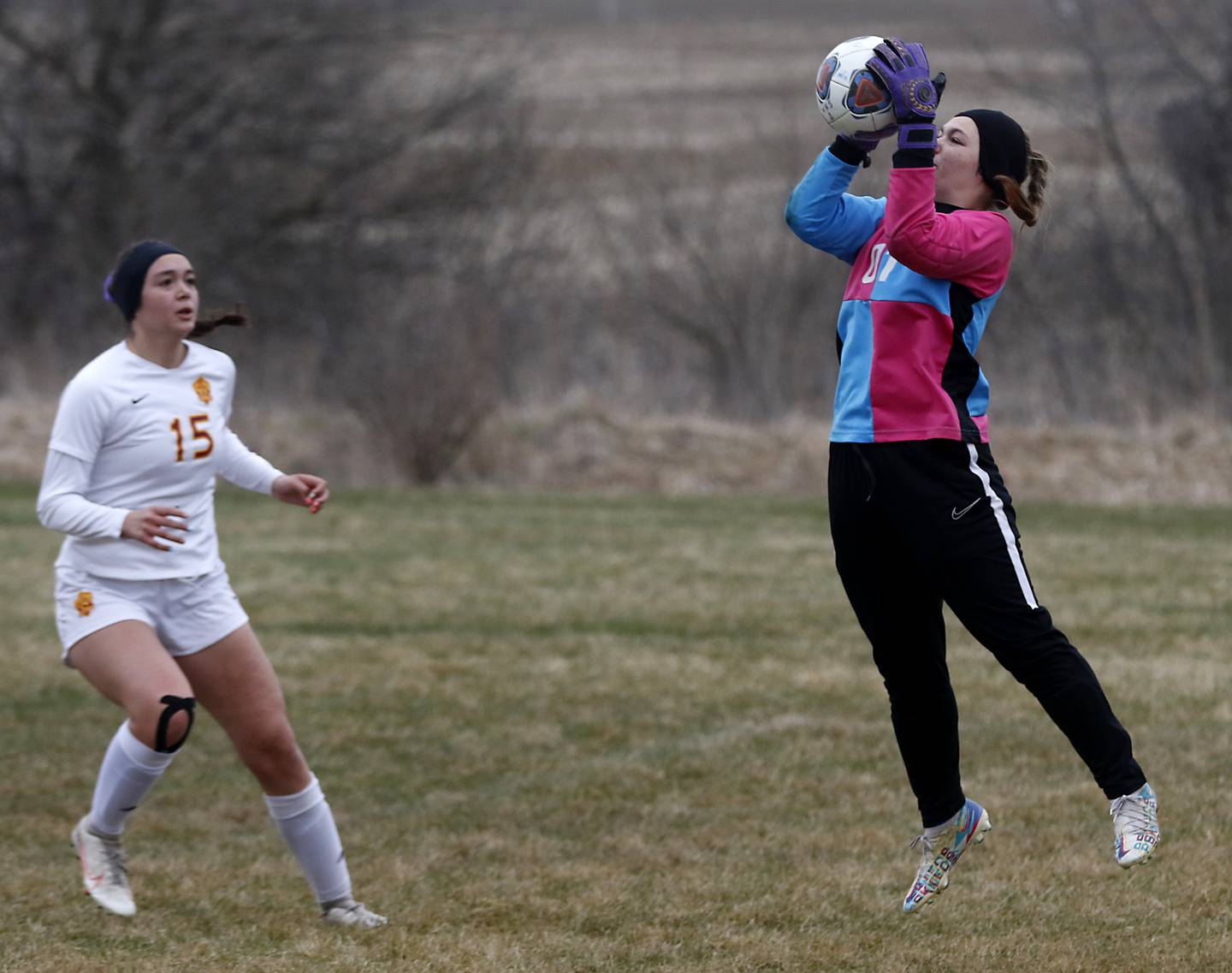 Woodstock's Valerie Sardelli grans the ball as Richmond-Burton's Brianna Maldonado runs at her during a Kishwaukee River Conference soccer match Wednesday, April 30, 2022, between Richmond-Burton and Woodstock at Creekside Middle School.