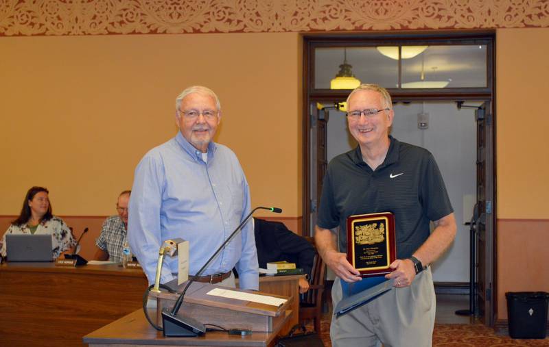 Dr. Tom Champley (right) holds a plaque presented by Ogle County Board Chairperson John Finfrock after being recognized during the Tuesday, Sept. 17,  2024, Ogle County Board meeting for almost 28 years of service as the Animal Control Department administrator.