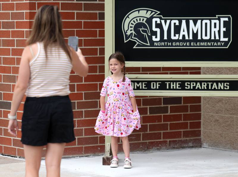Kindergartener Adeline Russell has her picture taken in front of the Spartan sign by her mom Colleen Thursday, Aug. 21, 2025, on the first day of school at North Grove Elementary School in Sycamore.