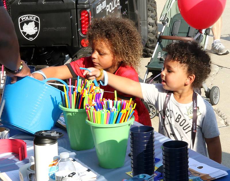 Xavier Humphrey, (left) 6, and Dierre Fields, 3, from Clare, pick out some items Tuesday, Aug. 5, 2025, at the Sycamore Police Department booth during National Night Out in the Hy-Vee parking lot in Sycamore.