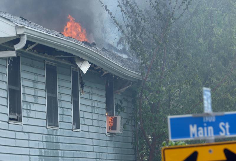 Flames pour out of the roof of a structure fire in the 1900 block of Main Street on Monday, May 4, 2026 in Peru.