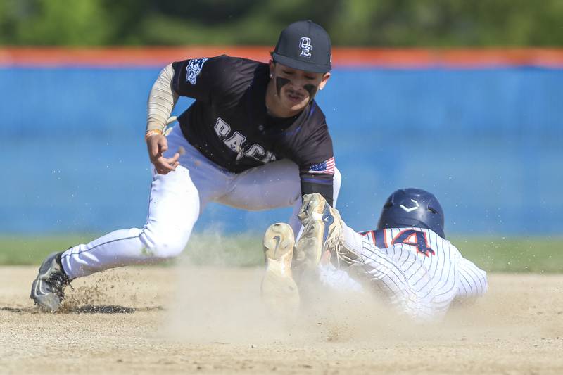 Oswego's Caleb Miller (14) slides into second while Oswego East's Devin Wheaton (2) attempts the tag during baseball game Oswego East at Oswego.  May 14, 2026 in Oswego.