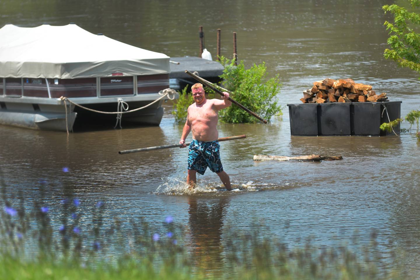 Sam Snider of Byron wades in the rising Rock River at the docking area at Rock River Terrace between Oregon and Byron on Monday, July 15, 2024. Snider was one of several residents who were scrambling to secure their boats and docks as river levels continued to rise due to heavy rains north of Ogle County over the weekend. Up to 10 inches of rain fell across Rockford on Saturday and Sunday causing streets to flood.