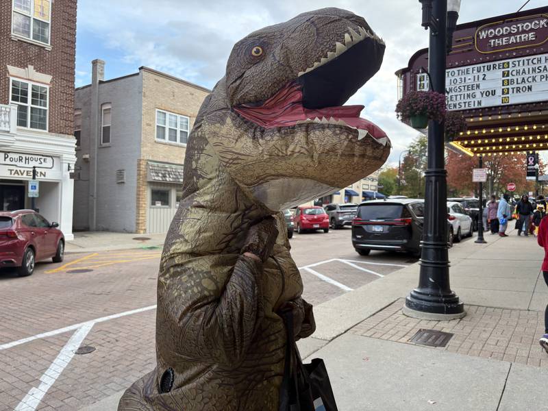 Alejandro Albarran of Woodstock shows off his dinosaur costume during Halloween on the Square in Woodstock Oct. 31, 2025.