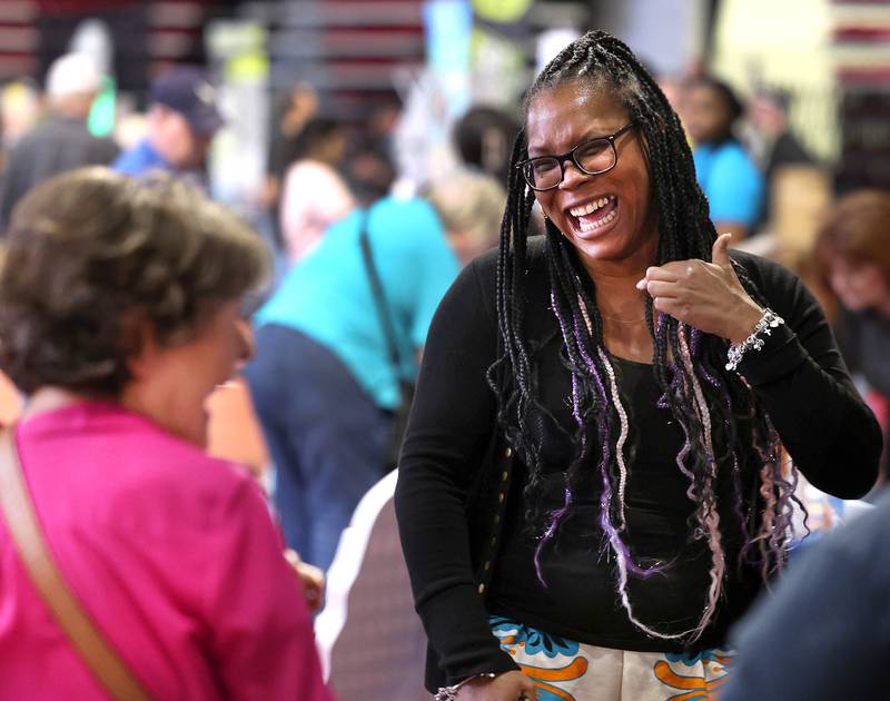 Sha Hill, with Family Service Agency, talks to attendees at their booth Thursday, April 24, 2025, during the Local Showcase and Spring Show in the Convocation Center at Northern Illinois University in DeKalb.