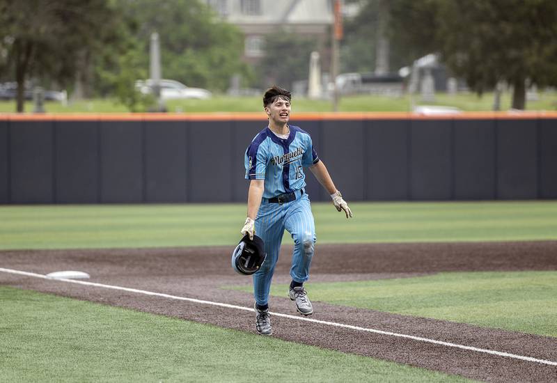 Ottawa Marquette’s Alec Novotney fires his helmet into the air after a walk off single to win the game against Father McGivney Saturday, June 7, 2025, during the Class 1A state baseball final at Illinois Field in Champaign.