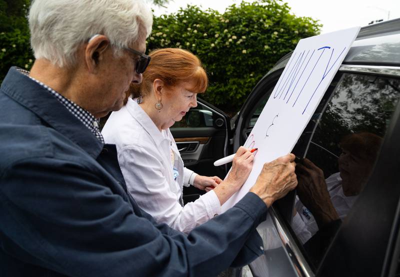 Patricia Golden makes a sign while her husband Loren Golden during a “No Kings Day” Protest against President Donald Trump’s policies along South Randall Road in Geneva on Saturday, June 14, 2025. “I can’t stand Trump so you got to speak up and speak out,” Loren Golden said. “He is a danger to our society.”