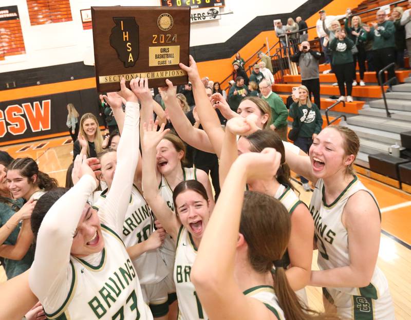 Members of the St. Bede Lady Bruins hoist the Class 1A Sectional plaque after defeating Serena on Thursday, Feb. 22, 2024 at Gardner-South Wilmington High School.