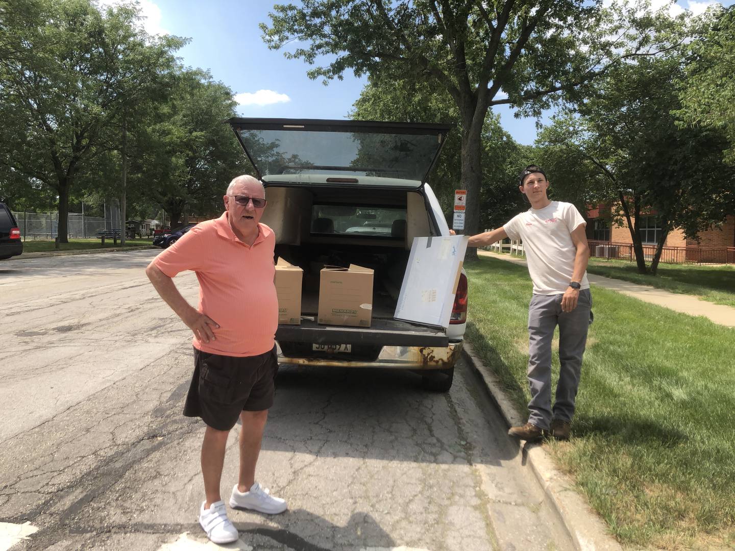 Richard Langford (left), chairman of the singles club at Carillon Lakes in crest Hill, helps deliver school supplies to the club collected to Chaney-Monge School District 88 and Richland School District 88A.
