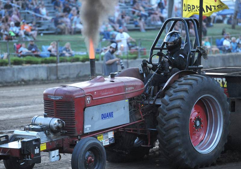 Fire shoots out of the tractor driven by Gary Zimmerly of Amboy in the Truck and Tractor Pull during the Kendall County Fair in Yorkville on Saturday, August 6, 2022.