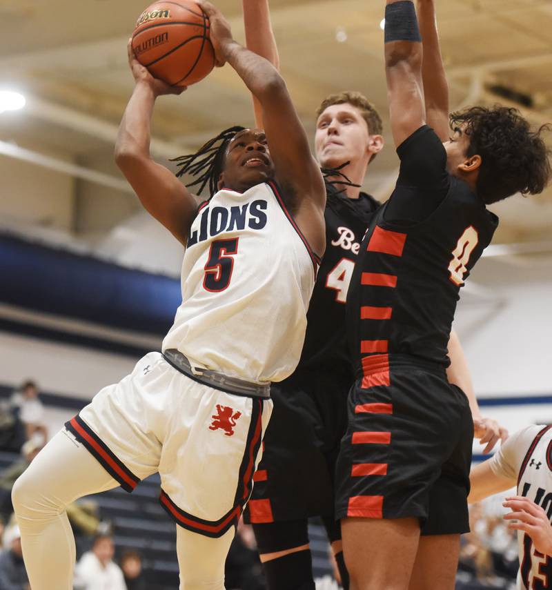 St. Viator's Montay Washington, left, goes to the basket against Benet Academy defenders Daniel Pauliukonis, middle and Blake Fagbemi on Friday, Jan. 5, 2024 in Arlington Heights.